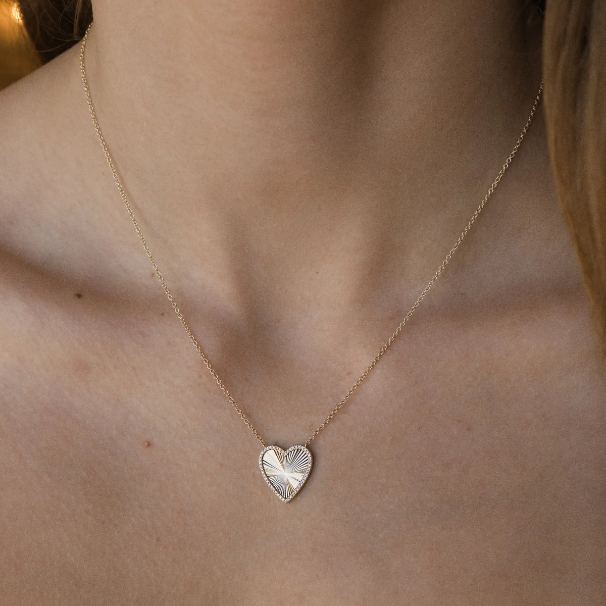 Woman wearing 14k gold diamond heart pendant necklace, layered necklace by Mama Bijoux