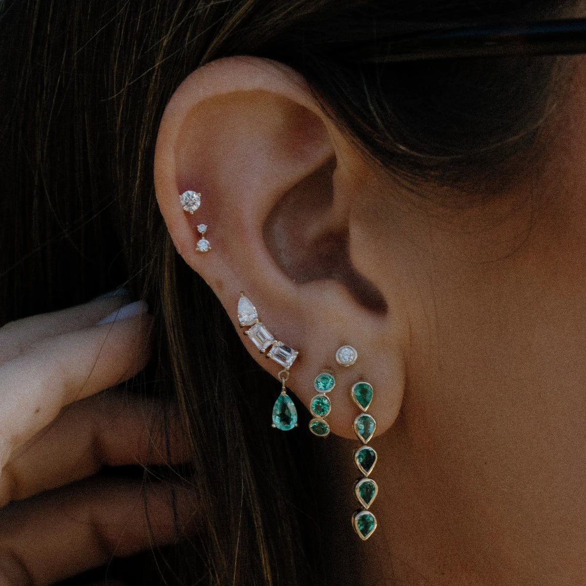 Bezeled emerald pear statement drop earring worn in ear stack with huggies and studs, emerald earrings by Mama Bijoux Orange County