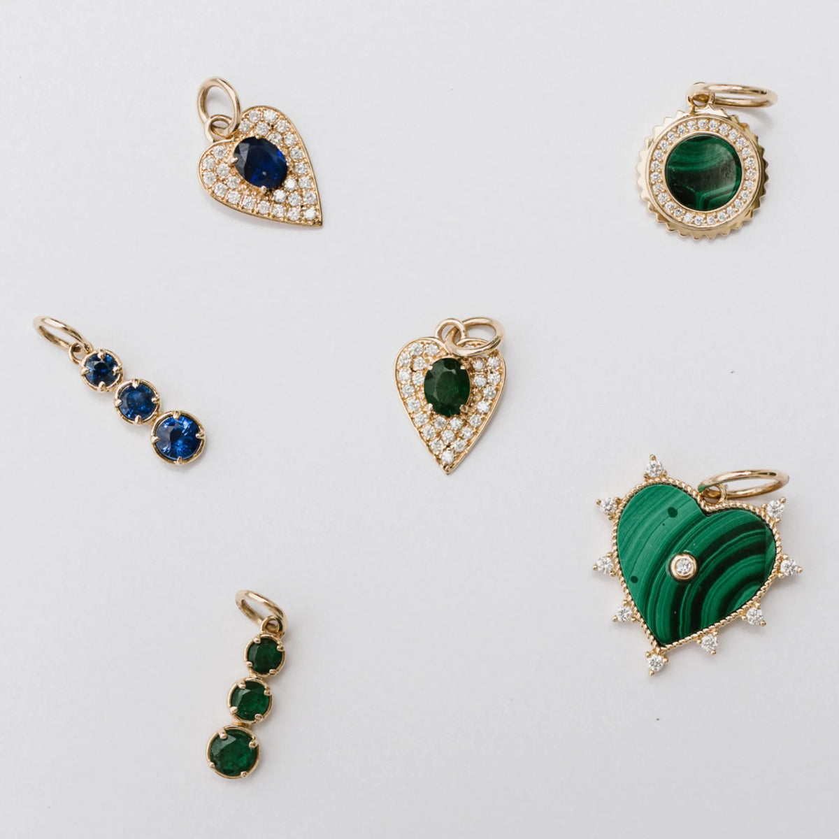 14k yellow gold graduated stone charms in emerald and blue sapphire shown in a jewelry flat lay, gemstone charm colorways by Mama Bijoux Costa Mesa