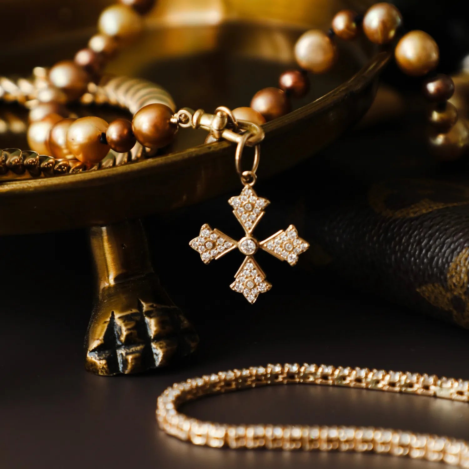 Gold necklace with a cross pendant on a dark surface