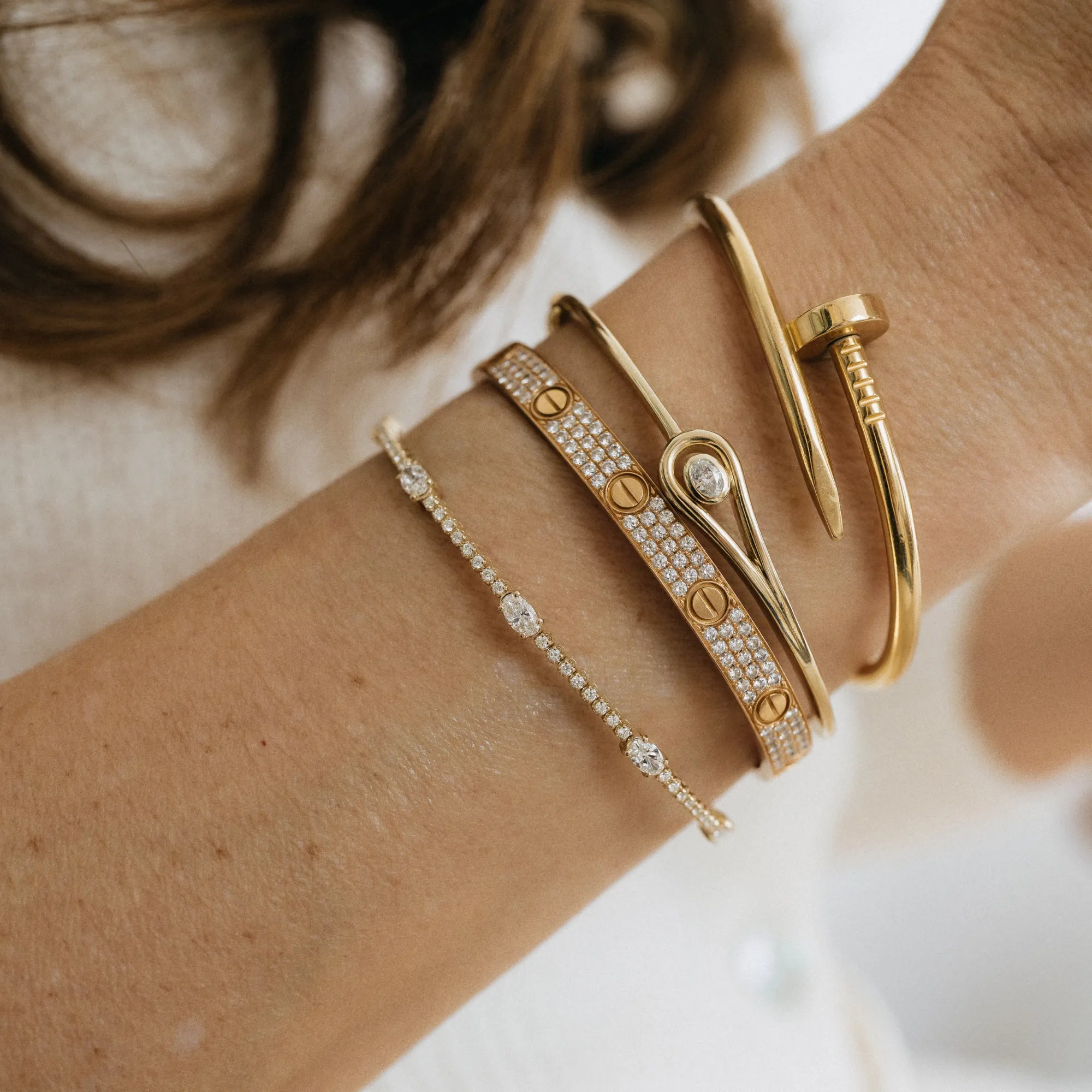 Natural round and lab oval cut diamond flexible bangle in curated wrist stack with diamond tennis bracelet gold chain bracelet and birthstone charms 14k yellow gold Mama Bijoux Costa Mesa