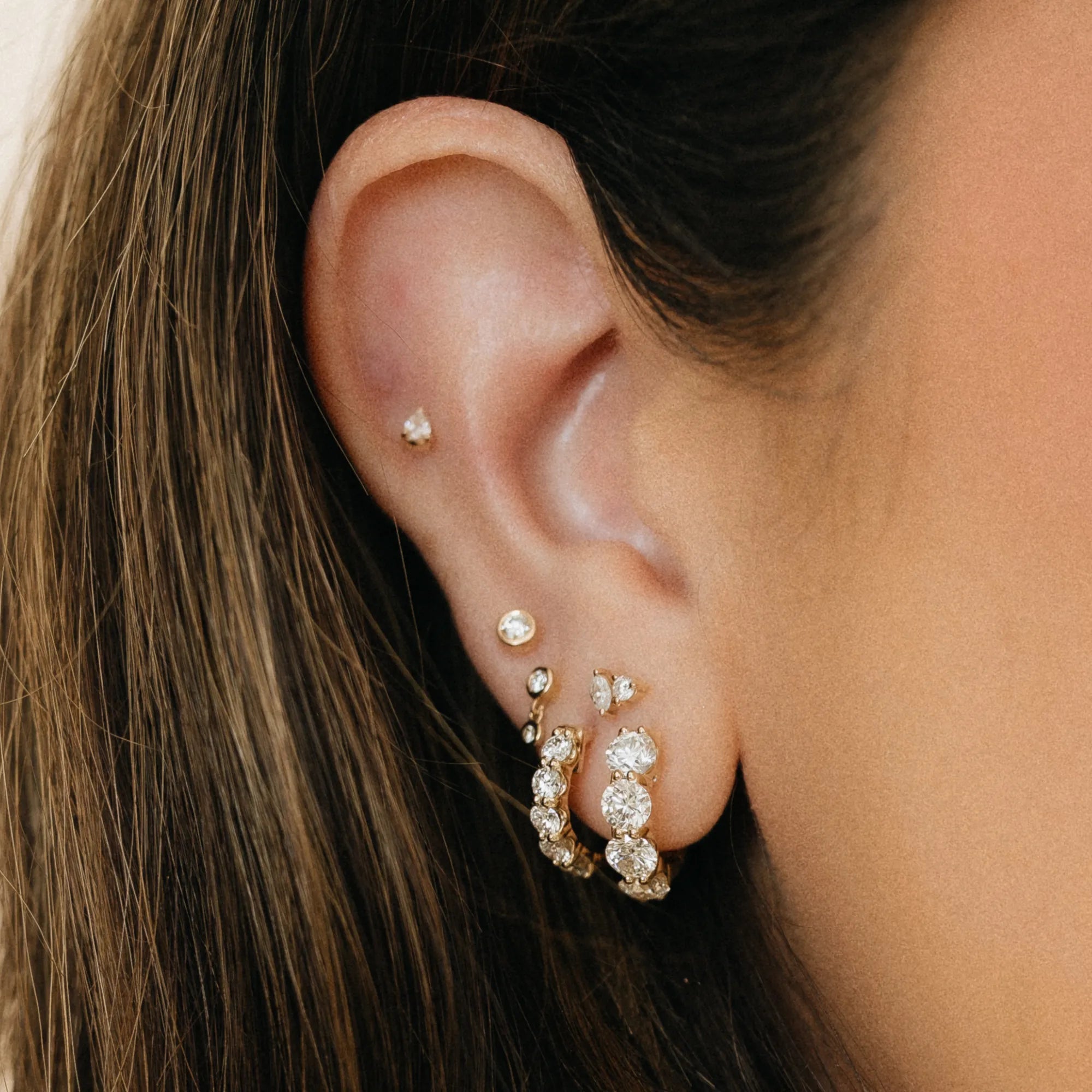 Shared prong natural diamond statement huggie earrings in curated ear stack with diamond studs and bezel earrings 14k yellow gold Mama Bijoux Costa Mesa