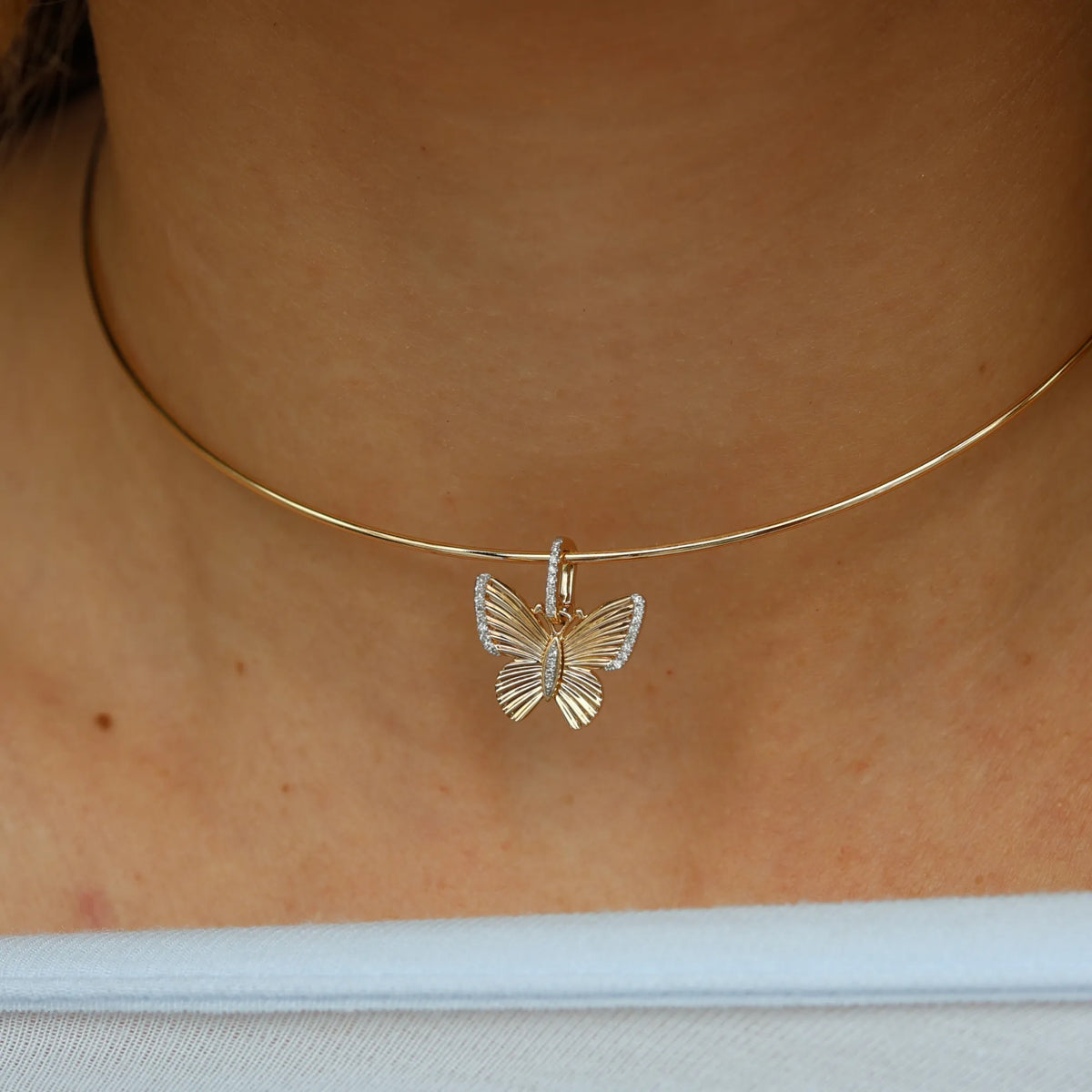 14k yellow gold pavé diamond butterfly charm on a wire collar necklace worn close on the neck, dainty layering pendant from Mama Bijoux fine jewelry, Costa Mesa California