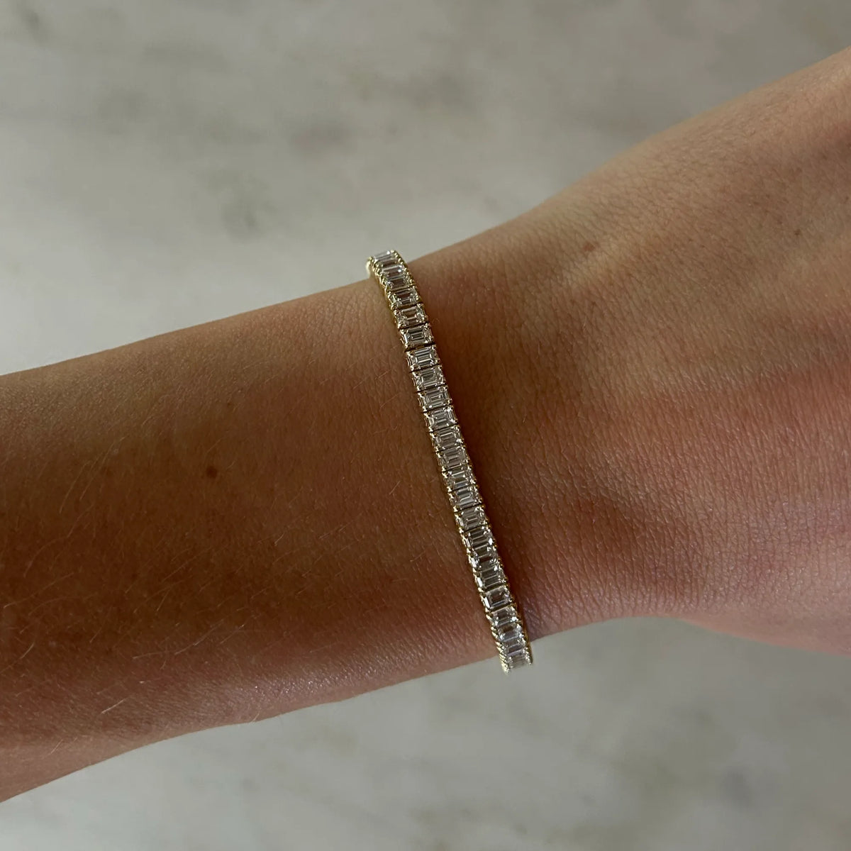14k yellow gold emerald cut lab diamond tennis bracelet worn on wrist, diamond tennis bracelet stack, everyday luxury fine jewelry, handmade jewelry Costa Mesa Orange County, Mama Bijoux