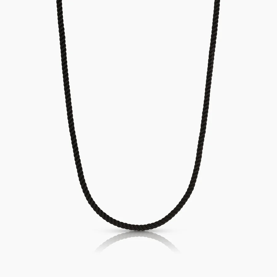 Sand-colored twisted silk cord necklace by THATCH styled with gold charm pendants