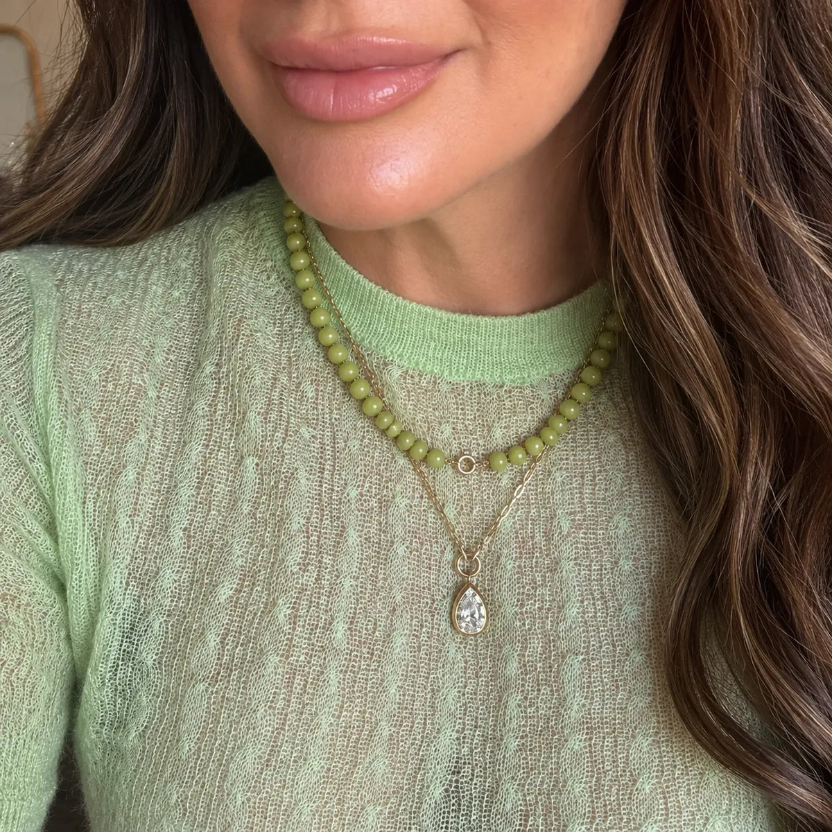 Lime green agate beaded necklace worn layered with a gold chain and pear-shaped stone pendant