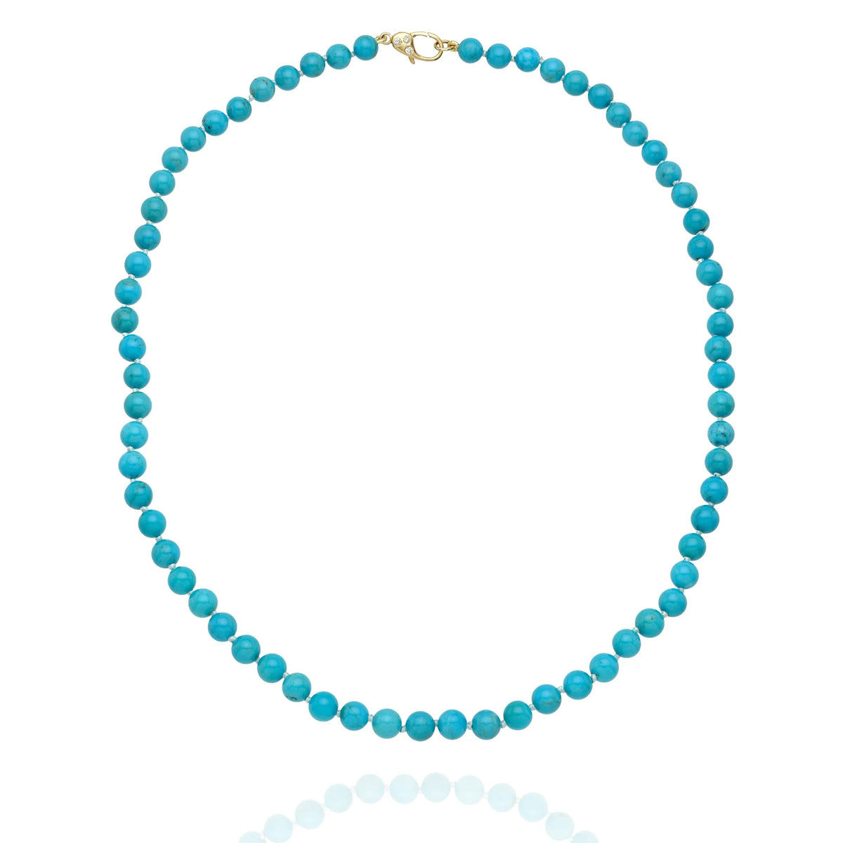 A turquoise beaded necklace with a gold clasp, displayed on a clean white background with a soft reflection below.