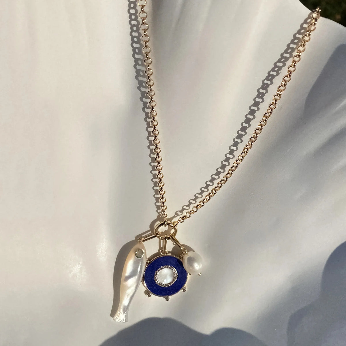 Necklace with blue pendant and pearl on a white background