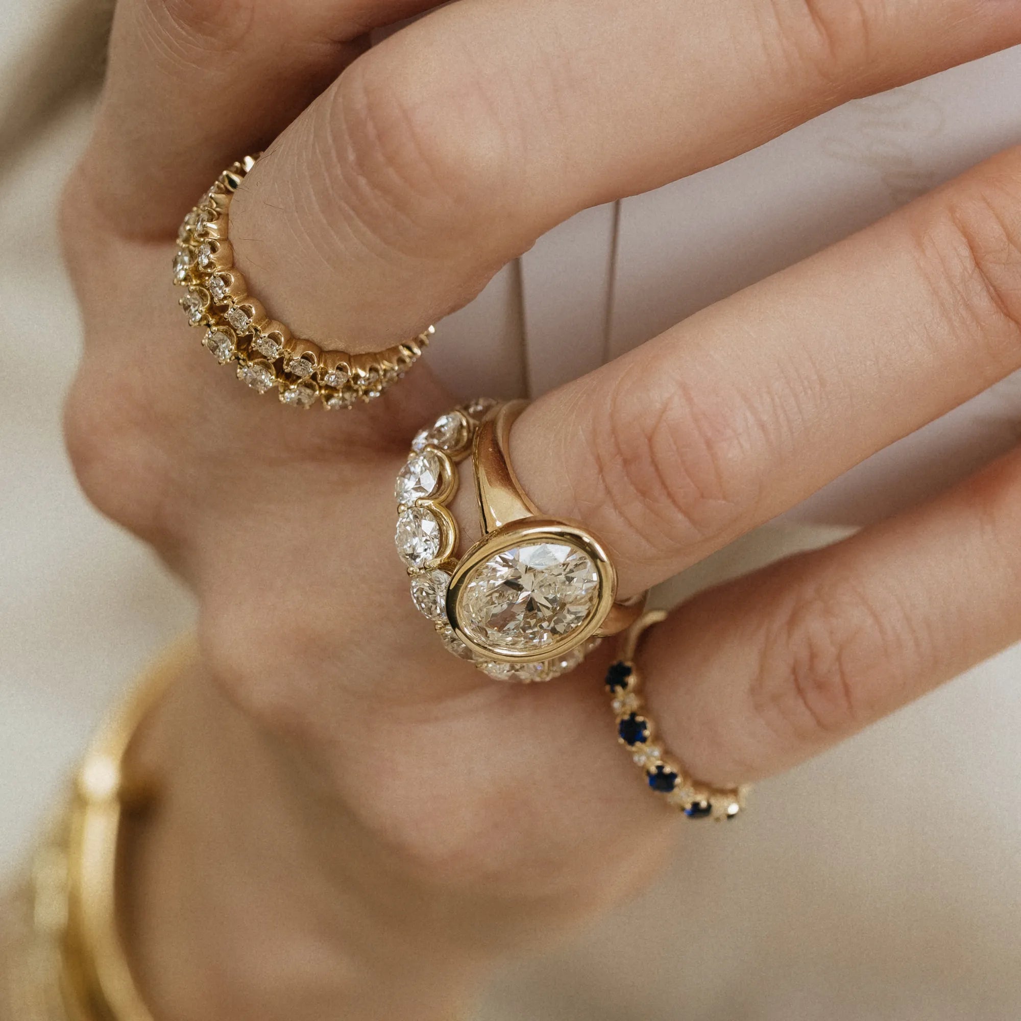Bezel set oval diamond engagement ring 14k yellow gold 3.07ctw lab grown diamond yellow gold bridal set diamond wedding band stacking ring lifestyle Mama Bijoux Costa Mesa