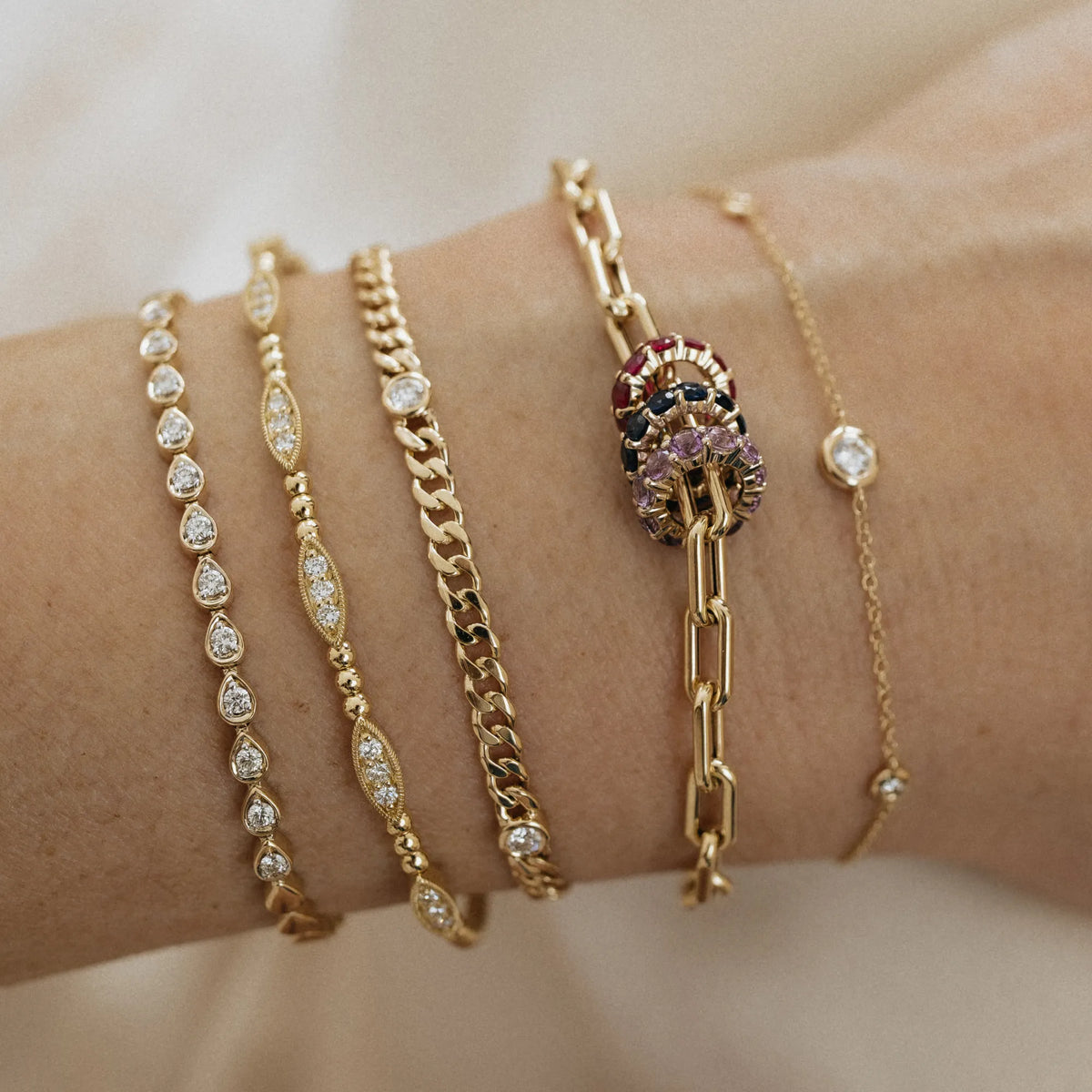 Stacked birthstone charm beads on 14k gold paperclip chain bracelet in curated wrist stack with diamond bracelets Mama Bijoux Costa Mesa