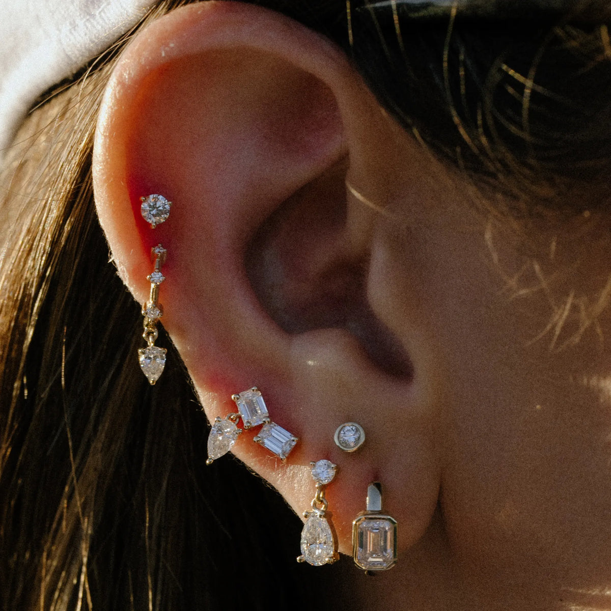 Emerald and pear lab diamond drop crawler worn along the ear with stud stack, everyday earrings by Mama Bijoux Orange County