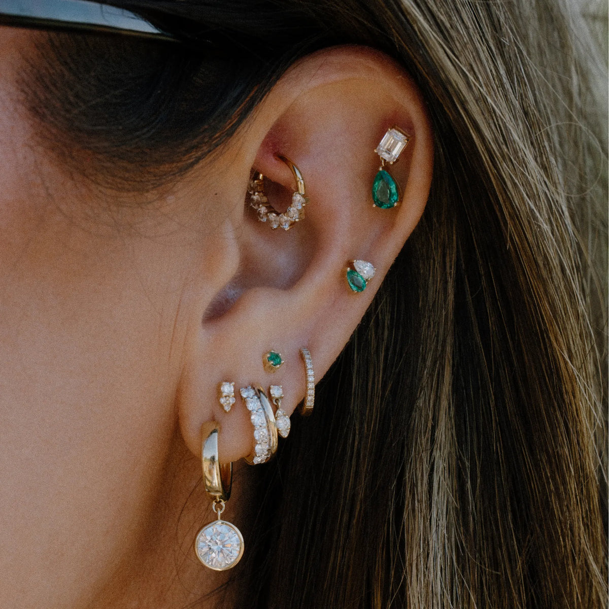 Emerald pear drop stud earring with lab diamond worn in ear stack with hoops and studs, gold emerald earrings by Mama Bijoux Orange County
