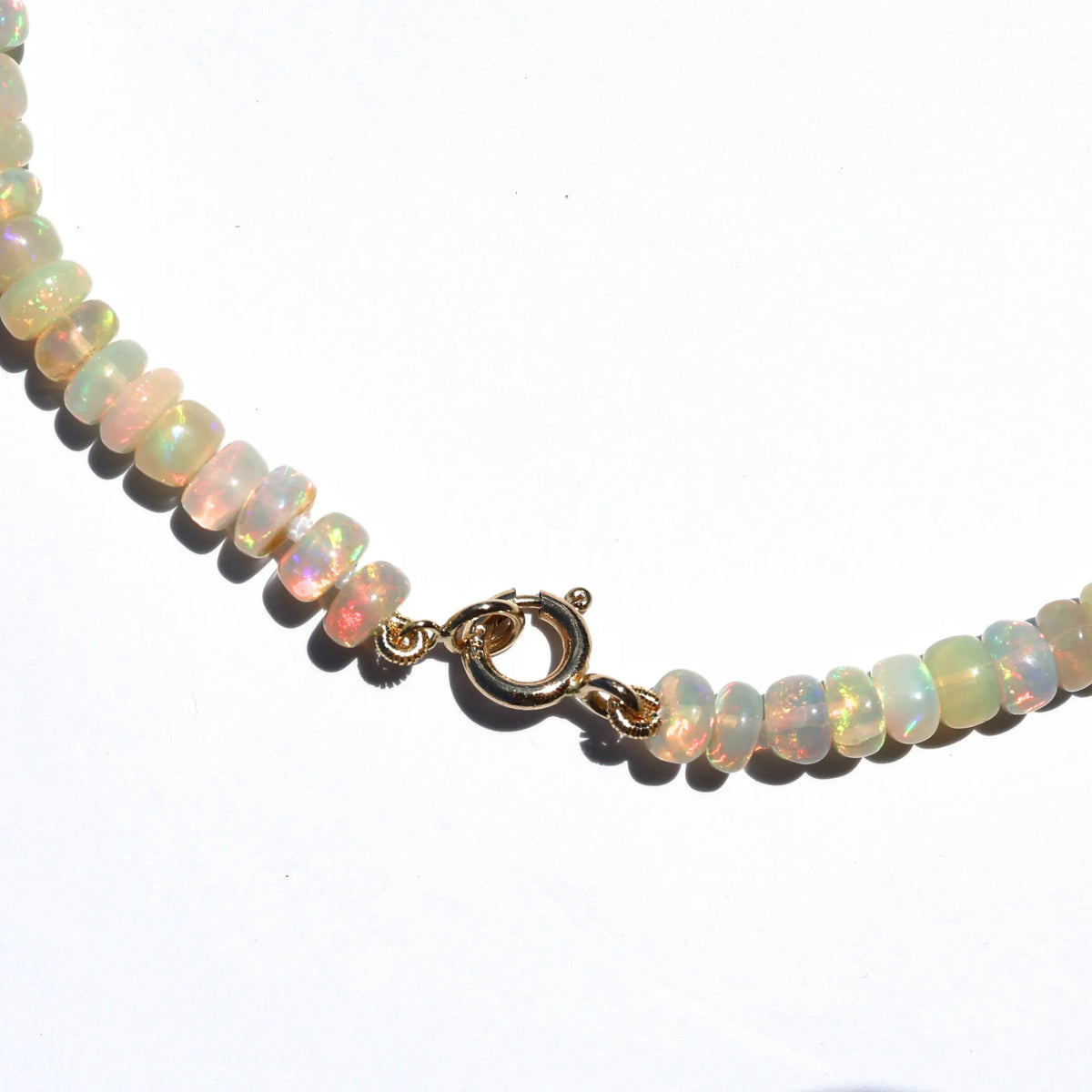 Close up of 14k gold charm clasp on fire opal beaded necklace Orange County jewelry
