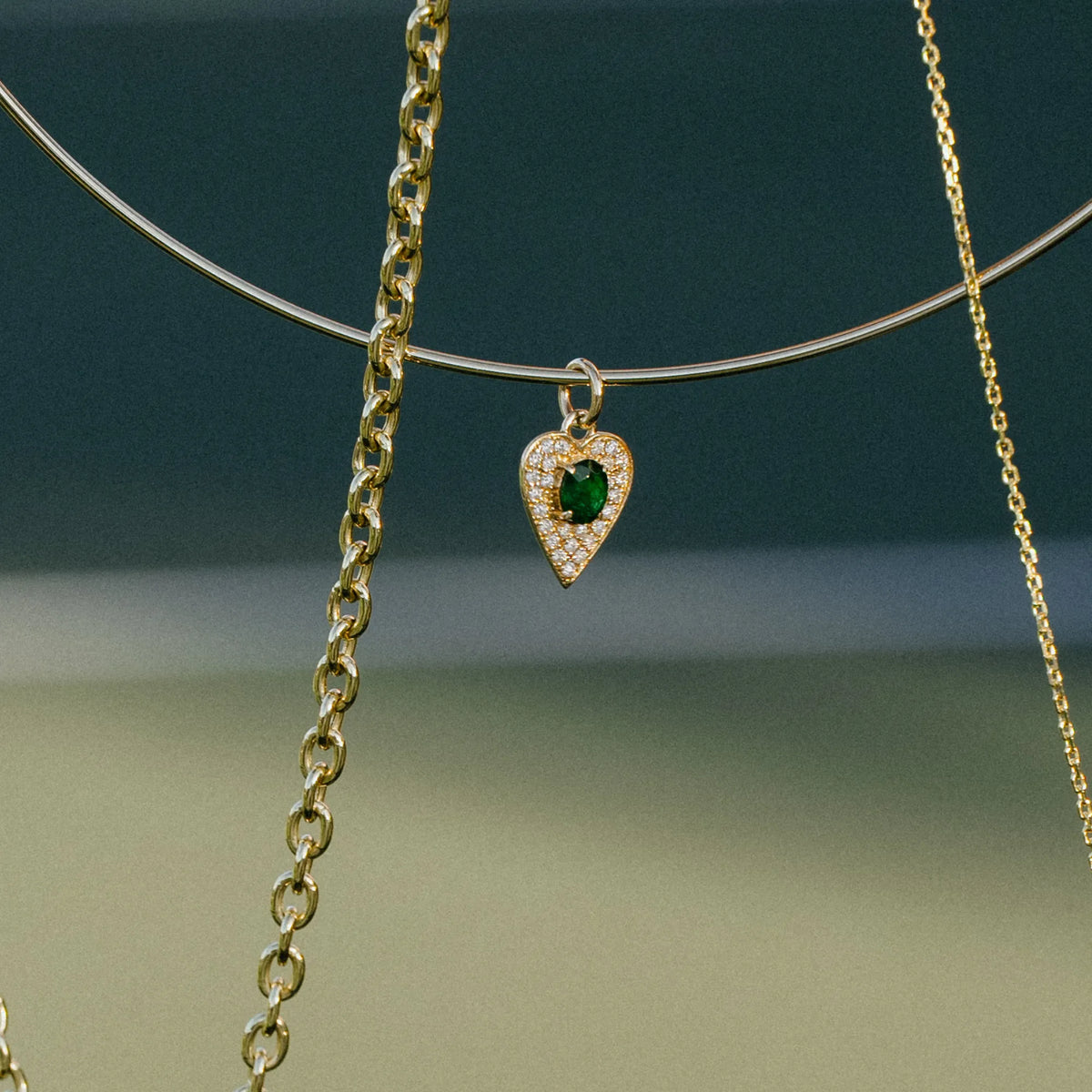 14k yellow gold diamond heart charm necklace with emerald center, everyday fine jewelry styled outdoors, Mama Bijoux Costa Mesa