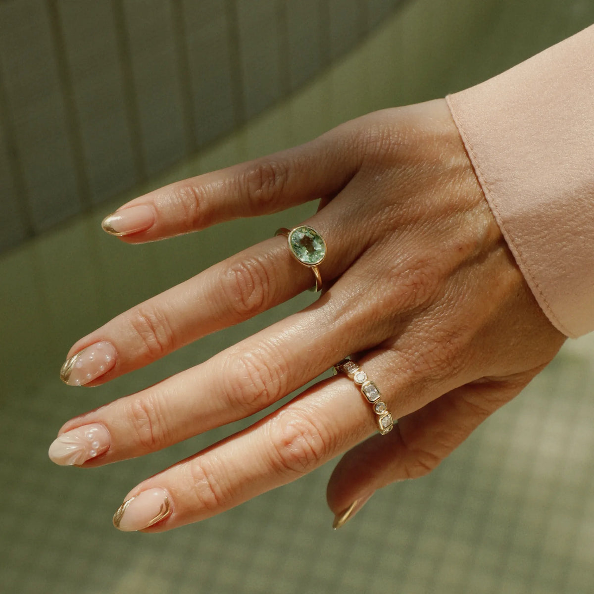 Lime green tourmaline east-west ring worn on the hand with a polished gold bezel setting