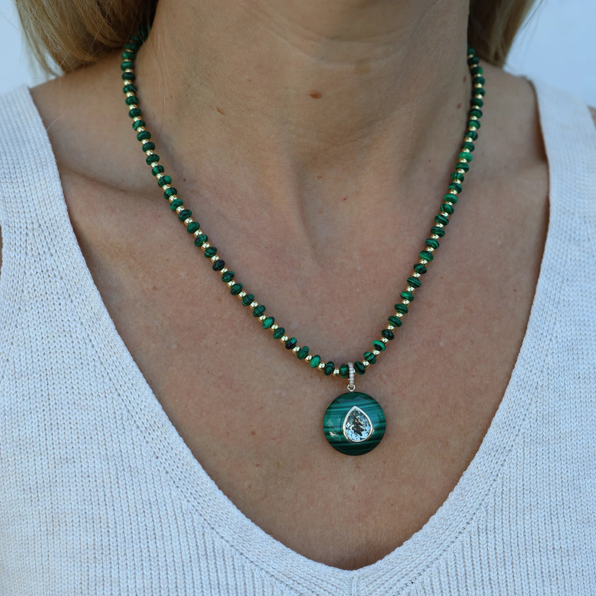 Model wearing the Malachite Muse necklace by Mama Bijoux x Isla Sol layered with a gold pendant necklace featuring natural malachite gemstone beads.