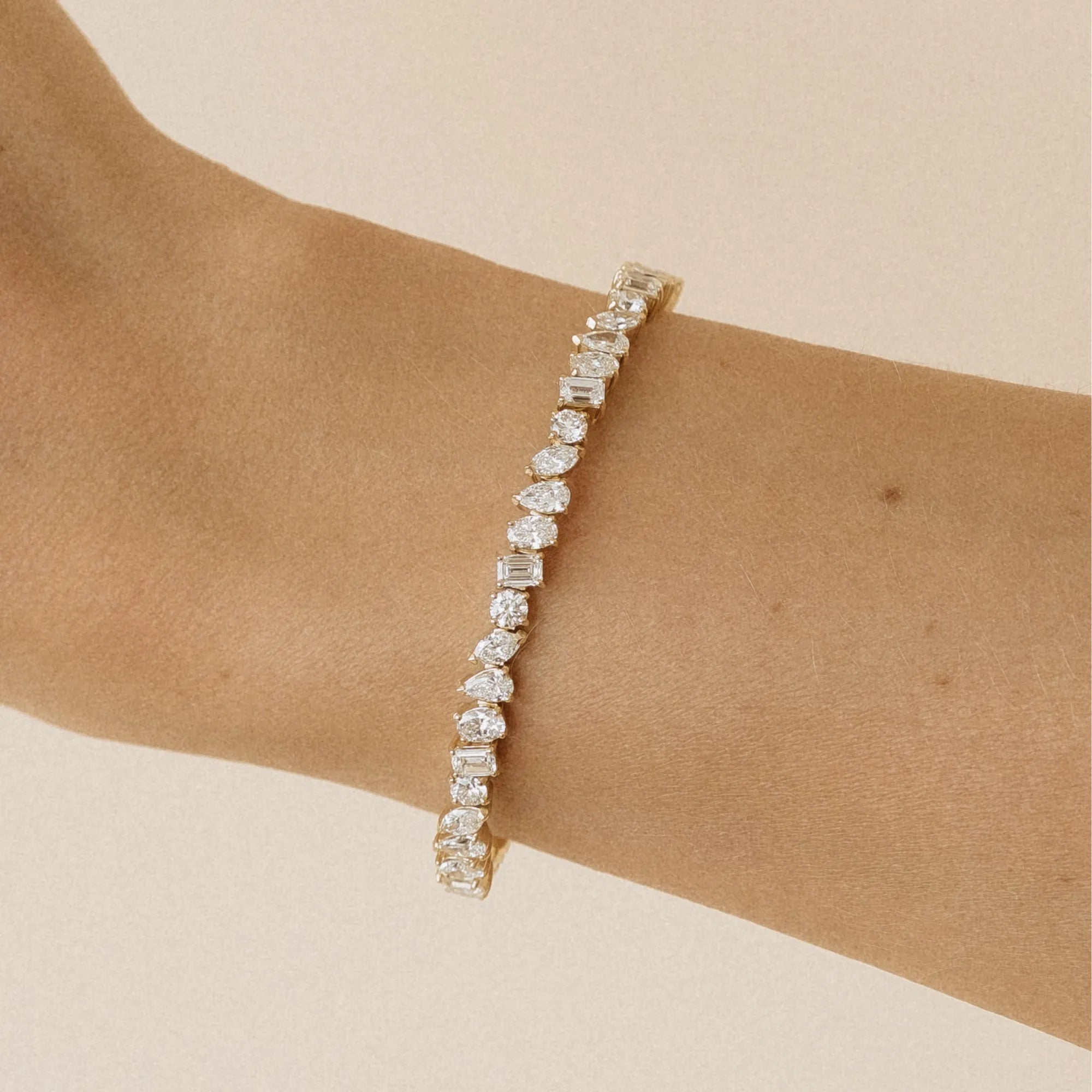 Multi cut lab diamond flexible bangle with emerald oval marquise pear and round diamonds worn on wrist 14k yellow gold Mama Bijoux Costa Mesa