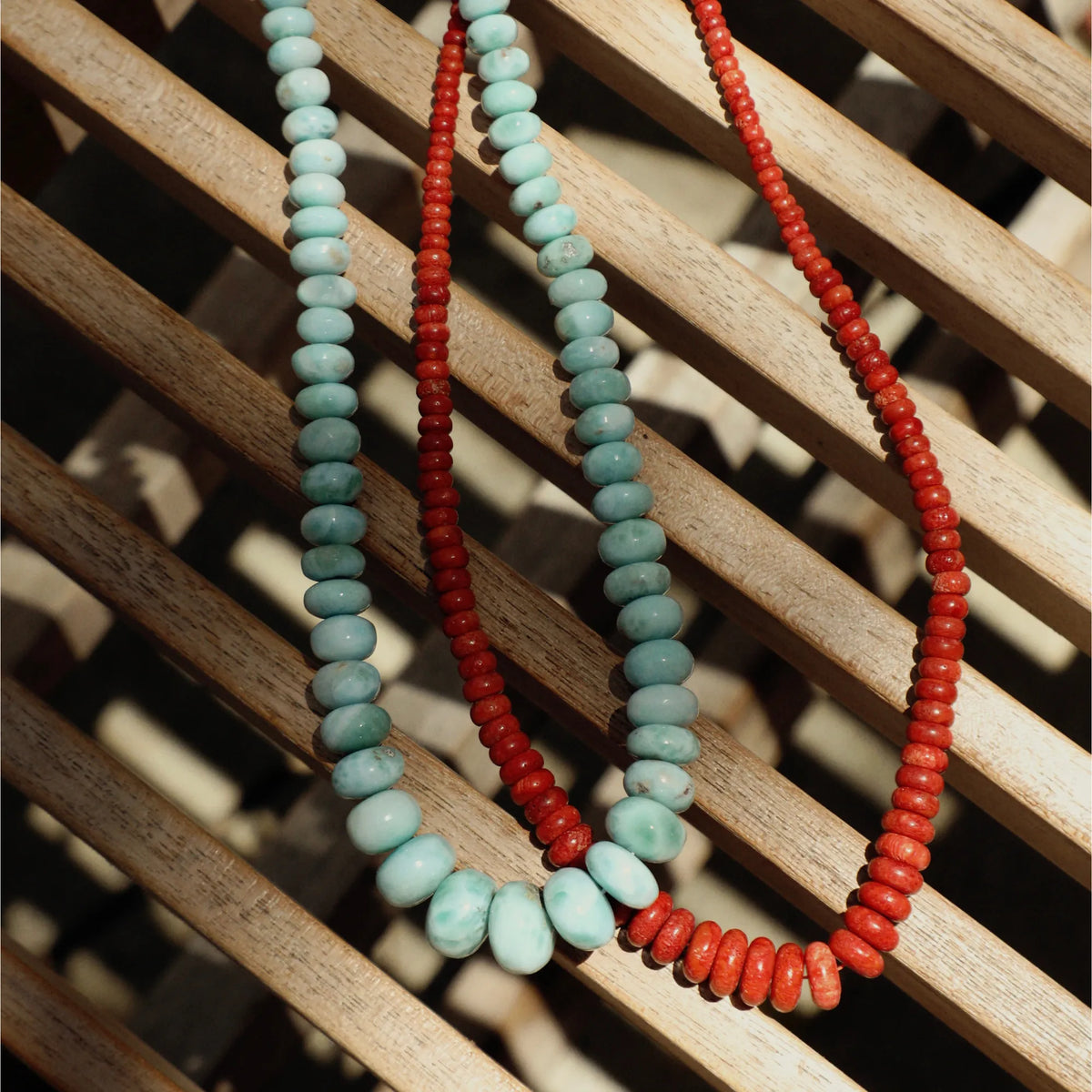 Natural coral graduated necklace styled with layered beaded necklaces and fine jewelry